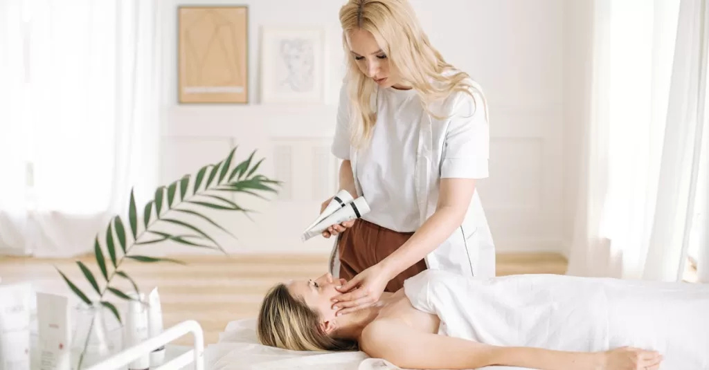 Aesthetician performing a facial treatment on a client in a serene spa clinic.